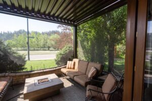 Screened patio with cushioned chairs and stylish fire table.